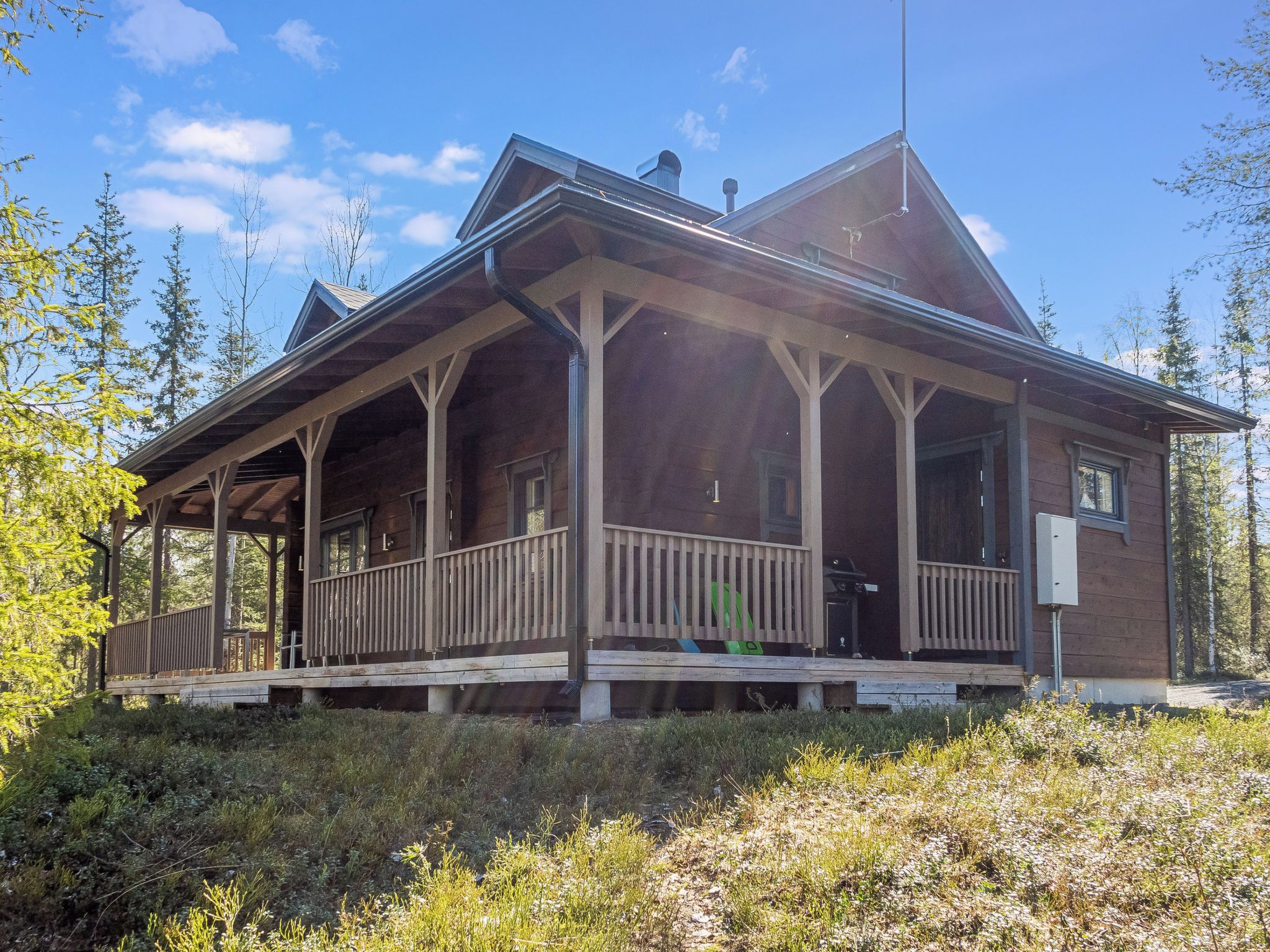 Eine Holzhütte mit Veranda, umgeben von Bäumen.