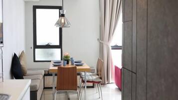Um espaço compacto com área de refeições, cozinha compacta e uma janela grande.