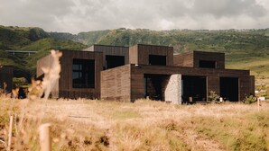 A modern building with a flat roof, large windows, and a stone base. - WOOD HOTEL & SPA (Trois-Bassins)