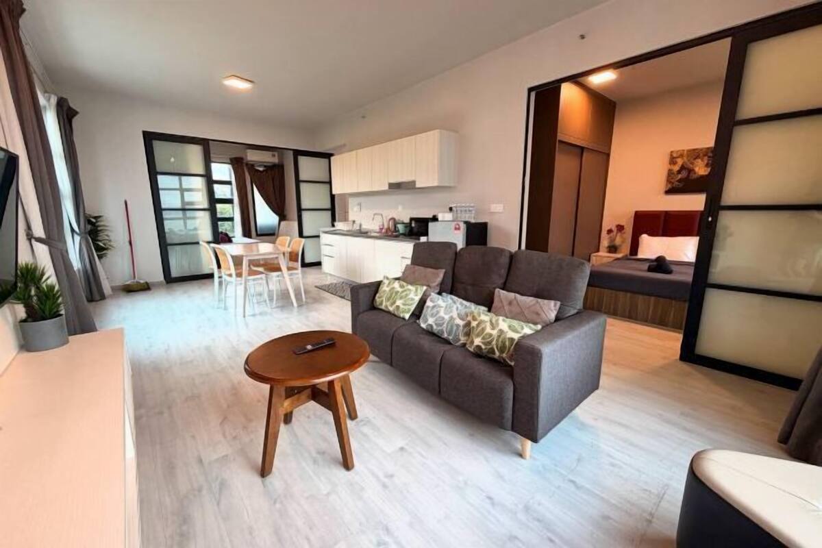 Ein modernes Wohnzimmer mit Sofa, Couchtisch und Essbereich mit Stühlen.