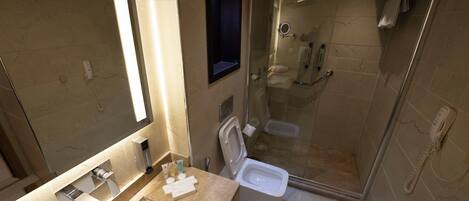 Une salle de bain moderne avec une douche à parois de verre, des toilettes séparées et un grand miroir.