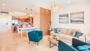 A modern living room with a sofa, chairs, a coffee table, and artwork on the wall. - Ocean View Apartment w/ Pool in Cap Cana (Punta Cana)