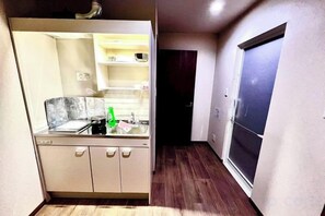 A compact kitchen with a built-in oven, a sink, and a countertop. - MIZUNOMICH IRYOKAN (Osaka)