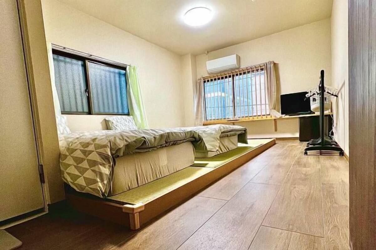 Een kleine kamer met een bed, een bureau en een stoel.