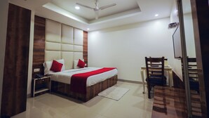 Ein modernes Schlafzimmer mit Bett, Nachttisch, Schreibtisch, Stuhl und Deckenventilator.