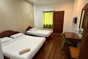 Een hotelkamer met twee bedden, een houten bureau, een stoel, een groen gordijn en een deur.