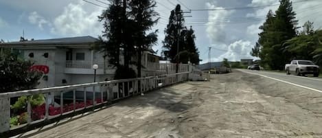 Una calle residencial con casas, un camino de tierra y cielo despejado.