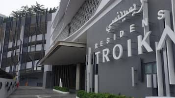 A modern building with the sign 'RESIDENS TROIKA' indicating a hotel or residential complex.