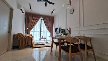 A modern living room with a dining area, a ceiling fan, a TV, and a large window with curtains.