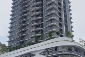 Un immeuble de grande hauteur doté d’une façade incurvée et de balcons.