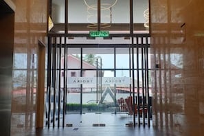 A hotel entrance with a glass door, a sign reading 'KELUARZ', and a view of the street outside.