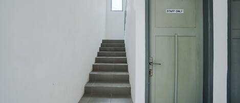 A staircase leading to a door marked "STAFF ONLY" with a small window above it.