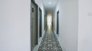 Um corredor com ladrilhos estampados no chão e portas em ambos os lados.