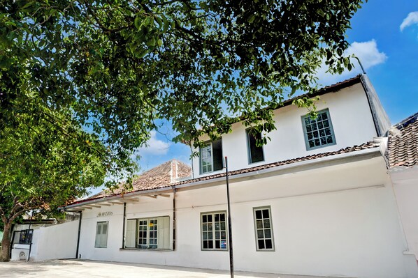 A white building with multiple windows and a tiled roof.