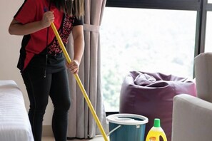 Una persona limpiando una habitación con un trapeador y un cubo.