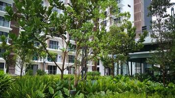 A modern building with multiple floors, surrounded by lush greenery and trees.