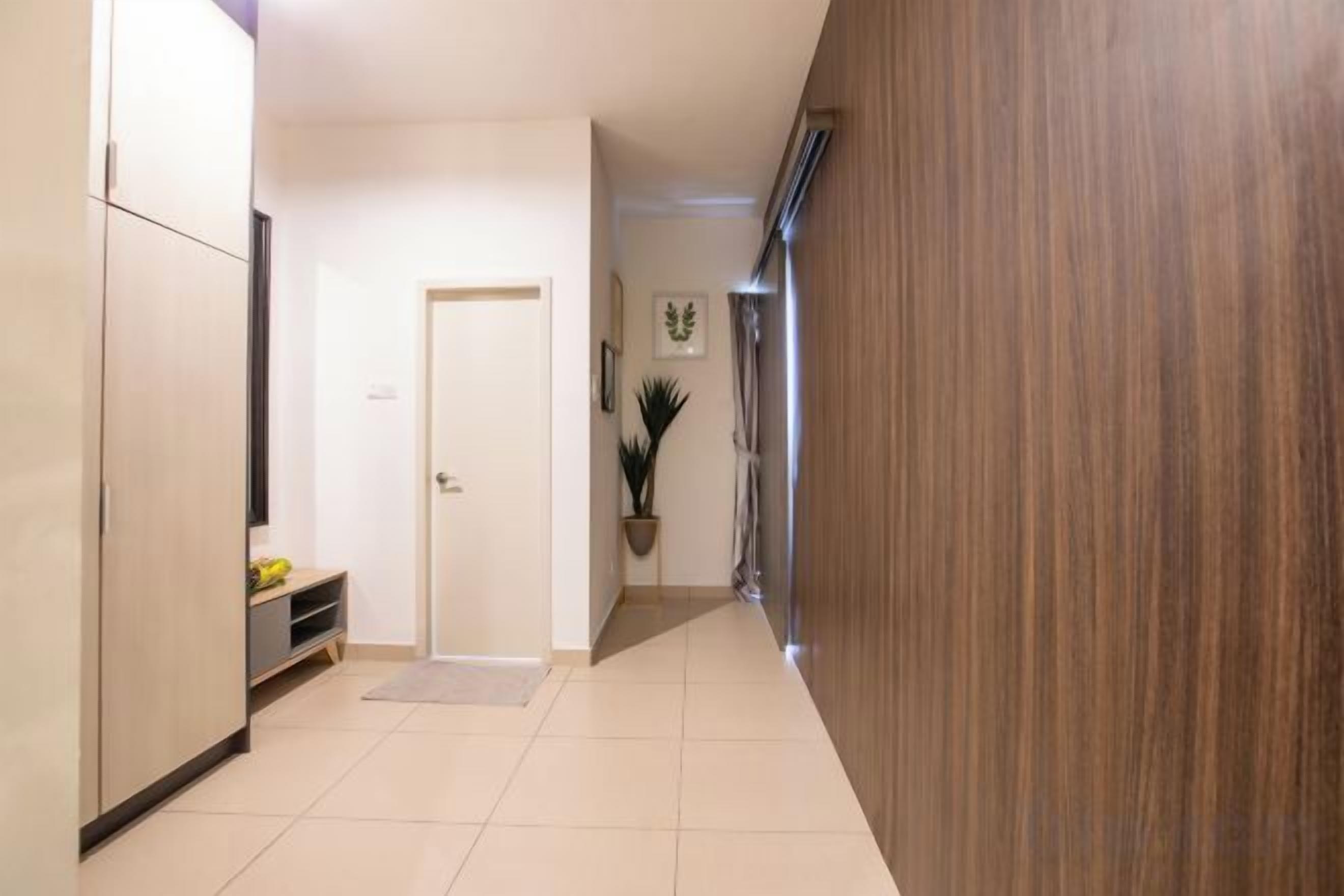 A hallway with a door, a bench, and a potted plant.