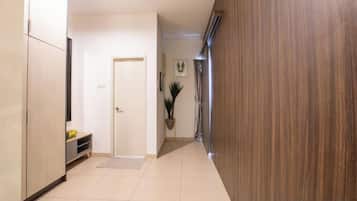 A hallway with a door, a bench, and a potted plant.