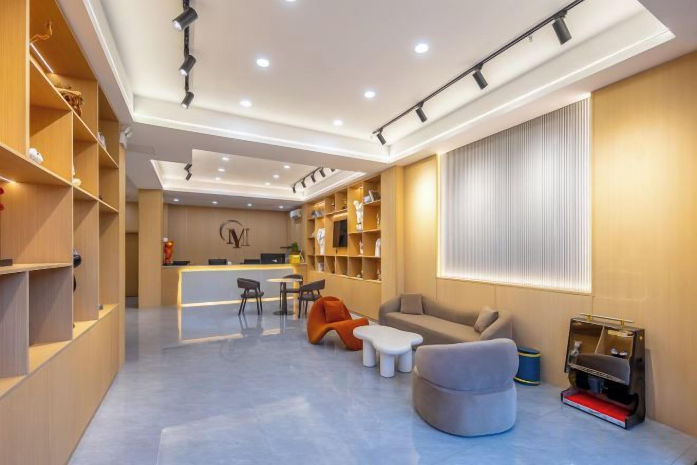 A modern interior with a reception desk, seating area, and bookshelves.