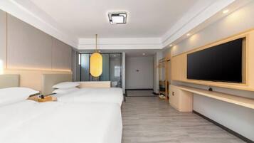 Et moderne hotelværelse med en stor seng, et fladskærms-TV, en loftlampe og et træ-TV-møbel.