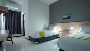 Una habitación de hotel con dos camas, un escritorio y una silla.