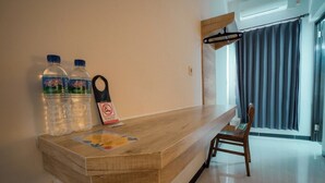 Un mostrador de recepción de madera con dos botellas de agua y un cartel de prohibido fumar.