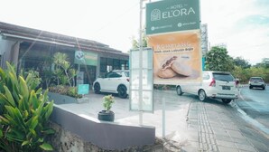 Un hotel llamado Elora con un letrero que anuncia Kompangan Bajo Oleh-Oleh Labuan Bajo Halal.