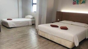 Une chambre d’hôtel avec deux lits, un plancher en bois et une fenêtre.