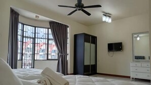 A hotel room with a bed, a ceiling fan, a TV, a wardrobe, and a window with curtains. - BUTTERWORTH RAJA UDA RAYA HOMESTAY (Butterworth)