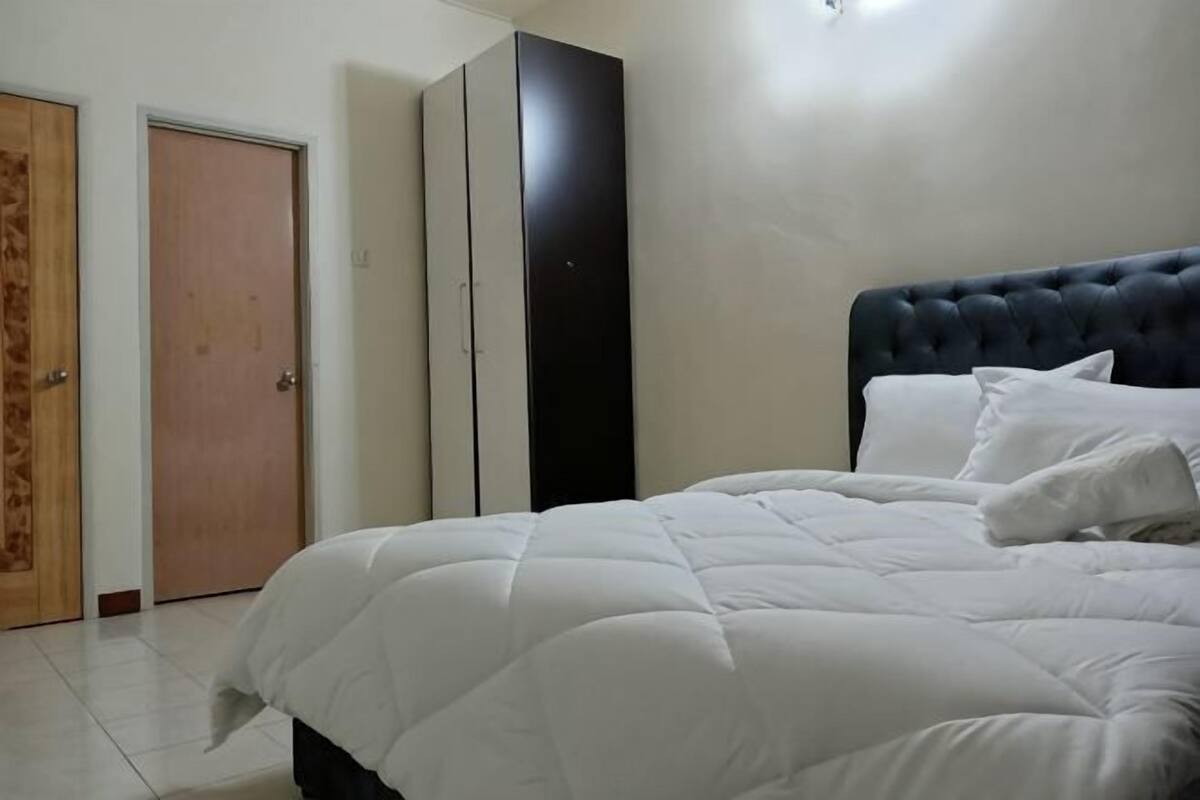 A bedroom with a bed, a wardrobe, and a door.