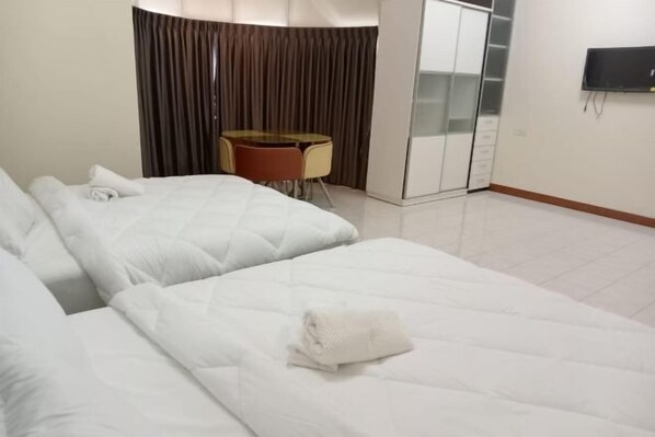 A hotel room with two beds, a desk, a chair, a TV, and a wardrobe. - BUTTERWORTH RAJA UDA RAYA HOMESTAY (Butterworth)