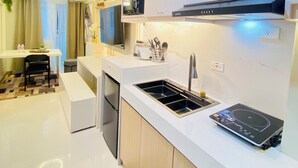 Une cuisine moderne dotée d’une cuisinière intégrée, d’un évier et de meubles de rangement blancs.