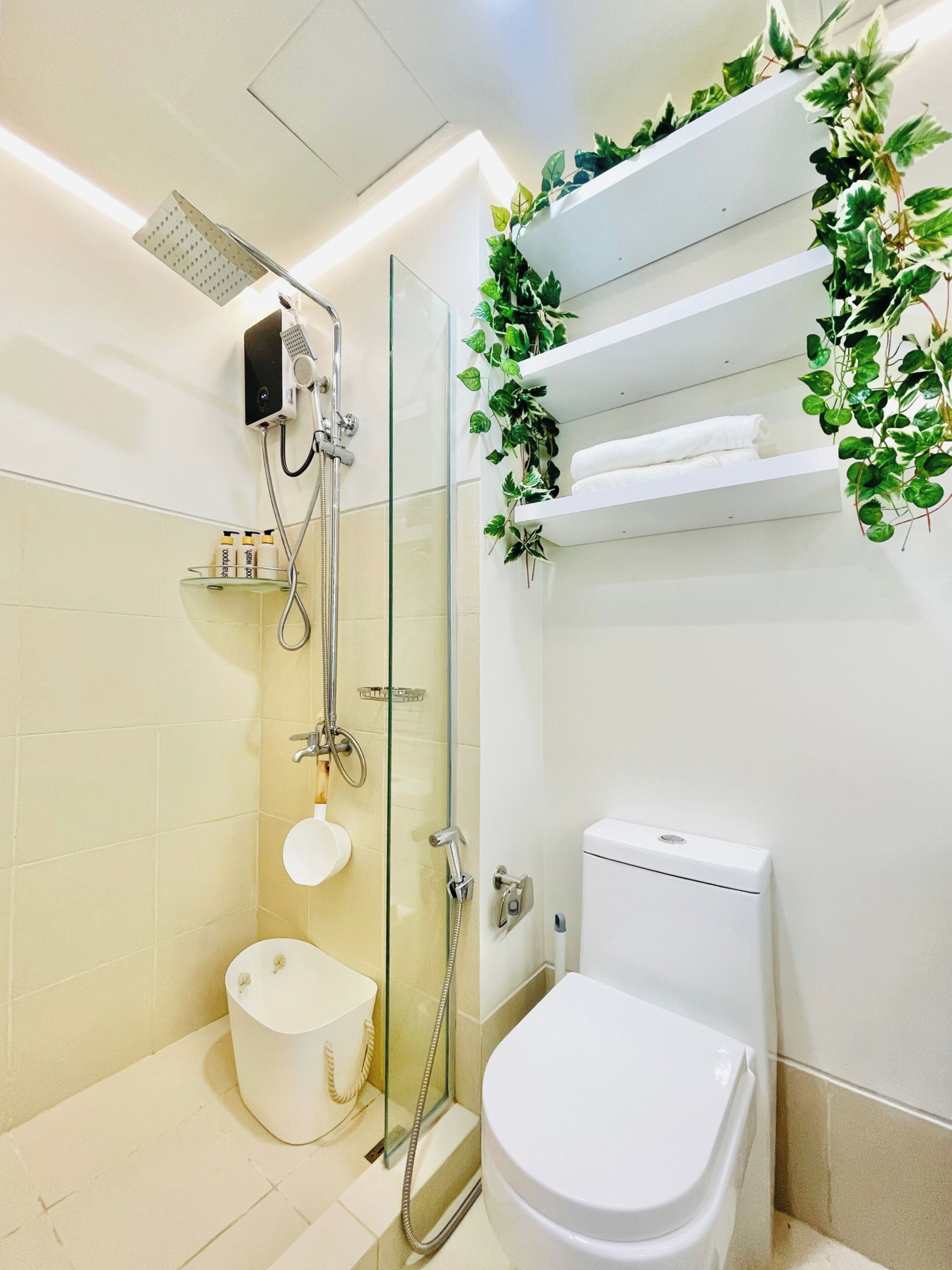 A modern bathroom with a glass-enclosed shower, a toilet, and a sink.