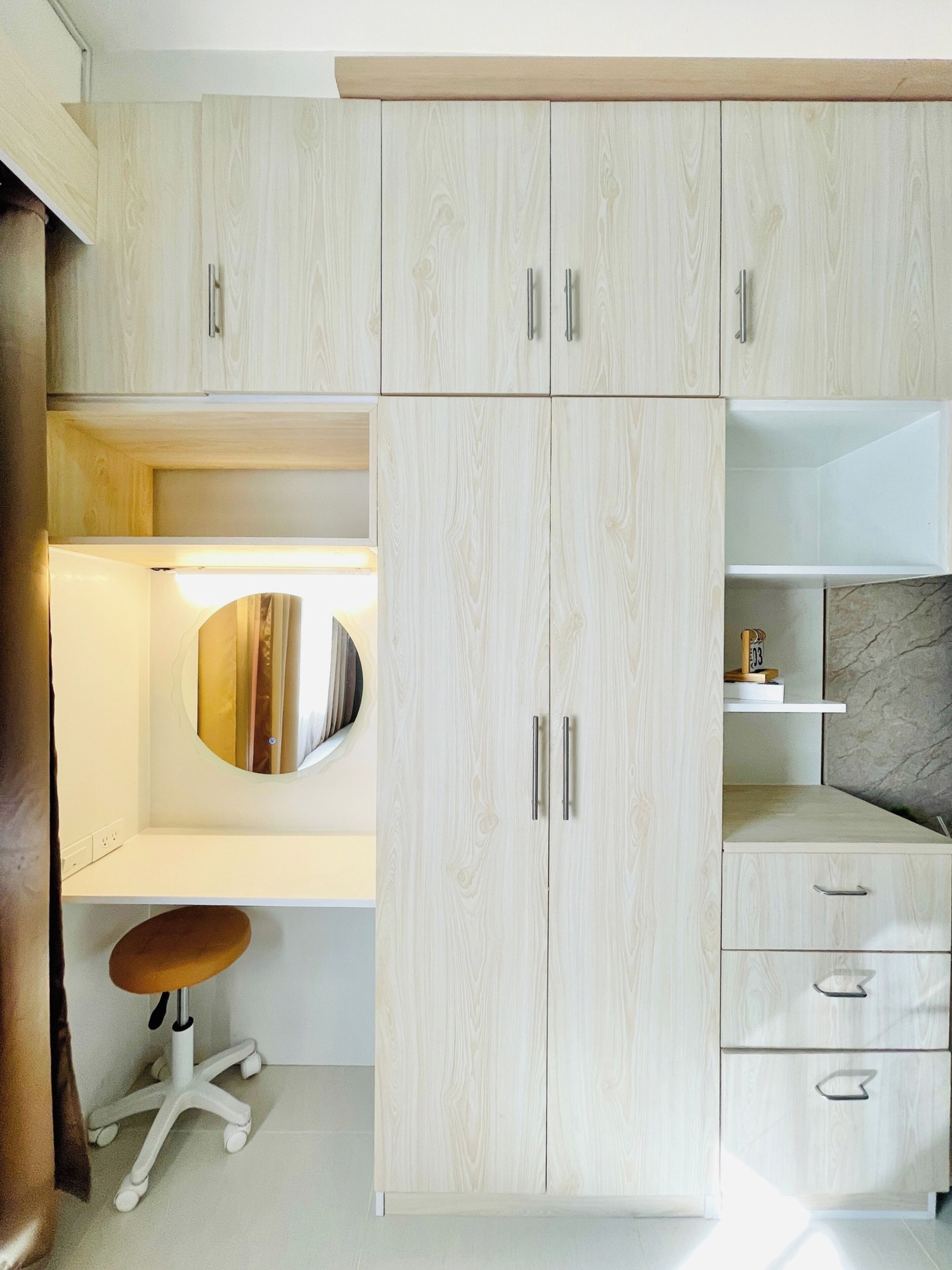A modern bedroom with a large wardrobe, a bedside table, and a mirror.