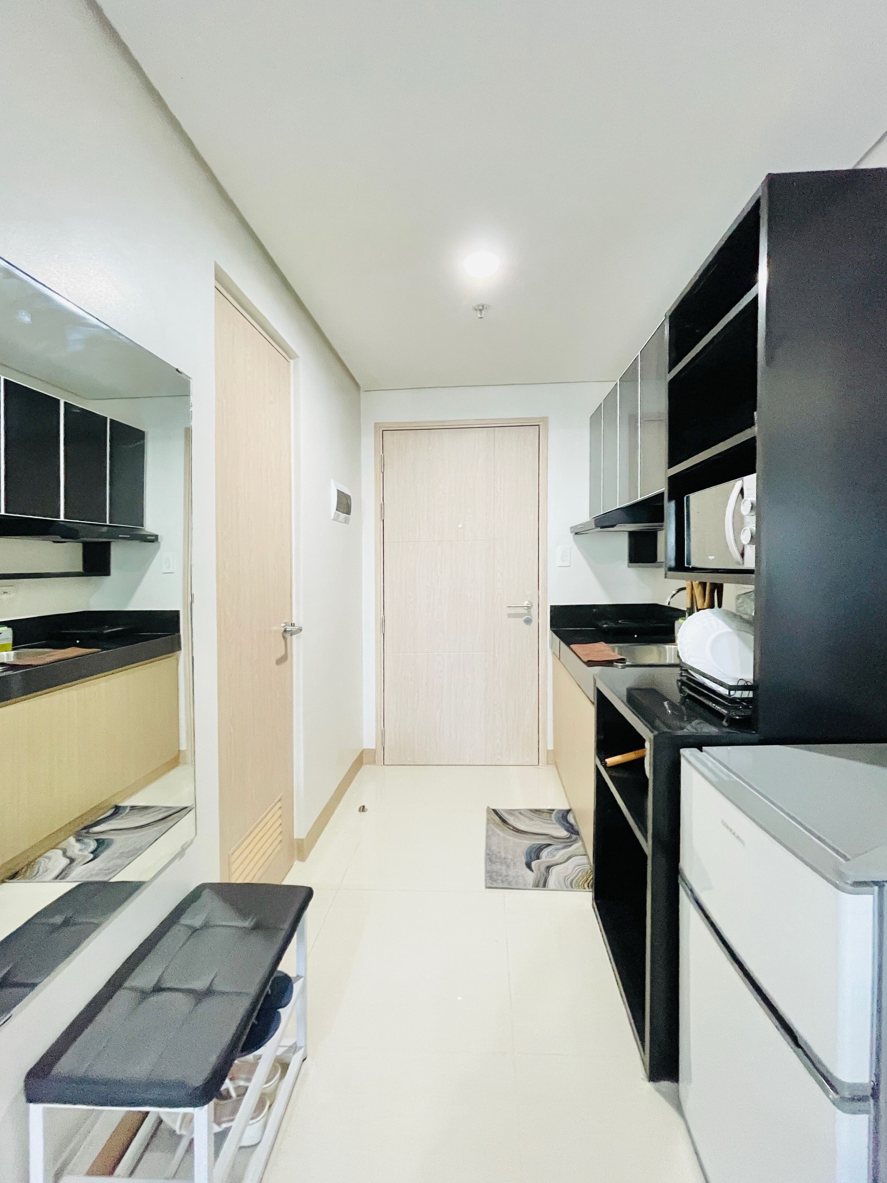 A compact kitchen with a refrigerator, stove, and cabinets.