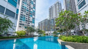 Piscina cercada por edifícios residenciais altos, com varandas.