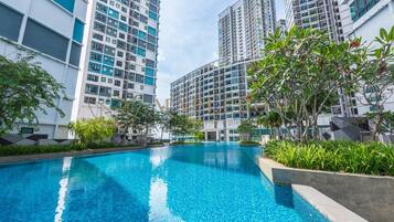 A swimming pool surrounded by high-rise residential buildings with balconies.