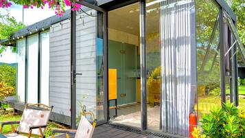 A modern house with a sliding glass door leading to a patio area with outdoor furniture.