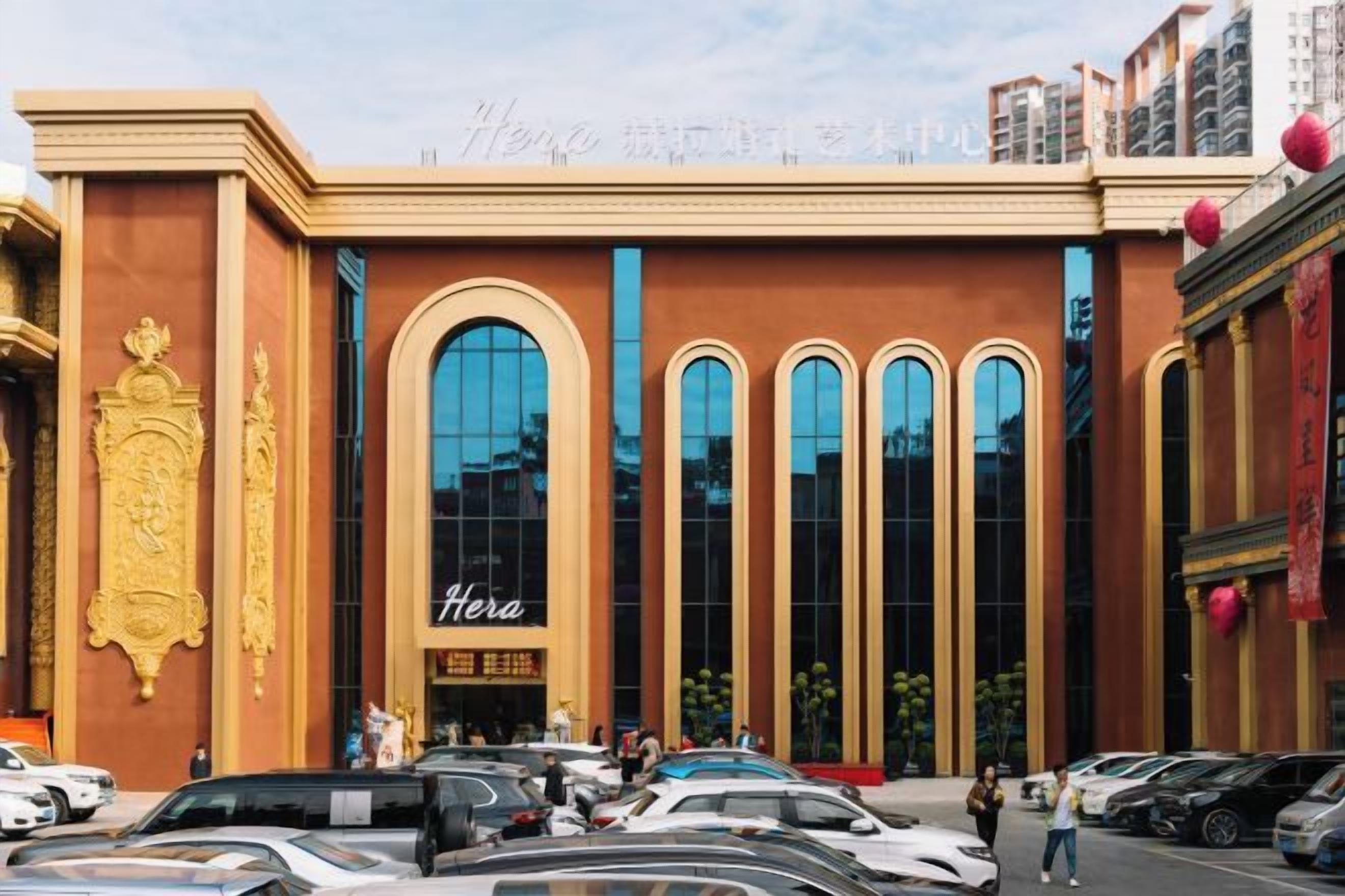 A building with a prominent entrance, large windows, and a sign that reads 'Hera.'