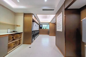 A hotel corridor with a reception desk, a laundry area, and a view of the outdoors.