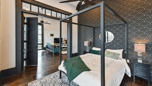 A bedroom with a four-poster bed, a ceiling fan, and a patterned wallpaper. - Chic 2-bedroom apartment in eclectic Bywater with AC, WiFi (New Orleans)