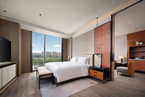 Une chambre d’hôtel moderne équipée d’un grand lit, d’un bureau, d’une chaise et d’une télévision.