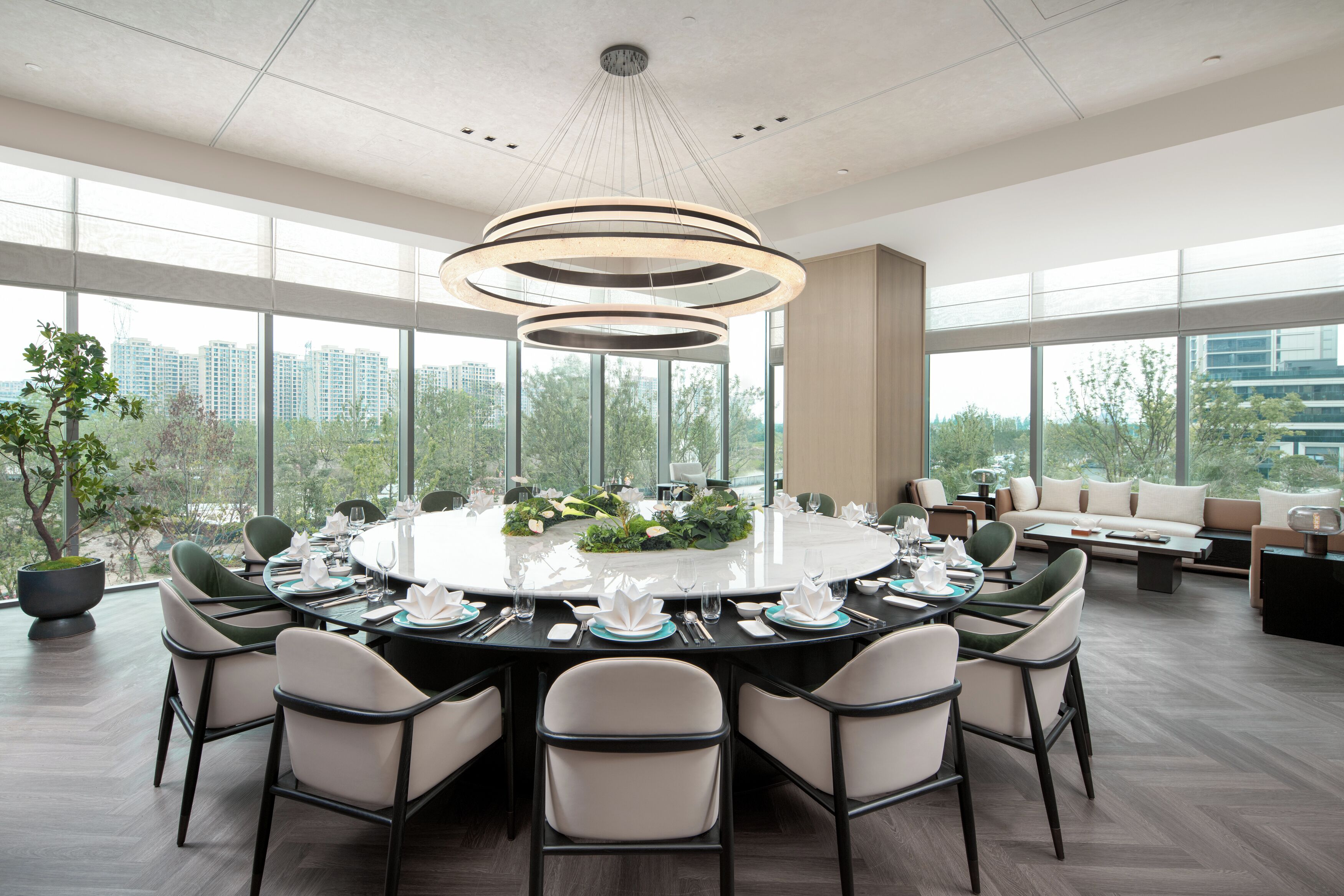 A modern dining area with a round table set for six, surrounded by chairs.