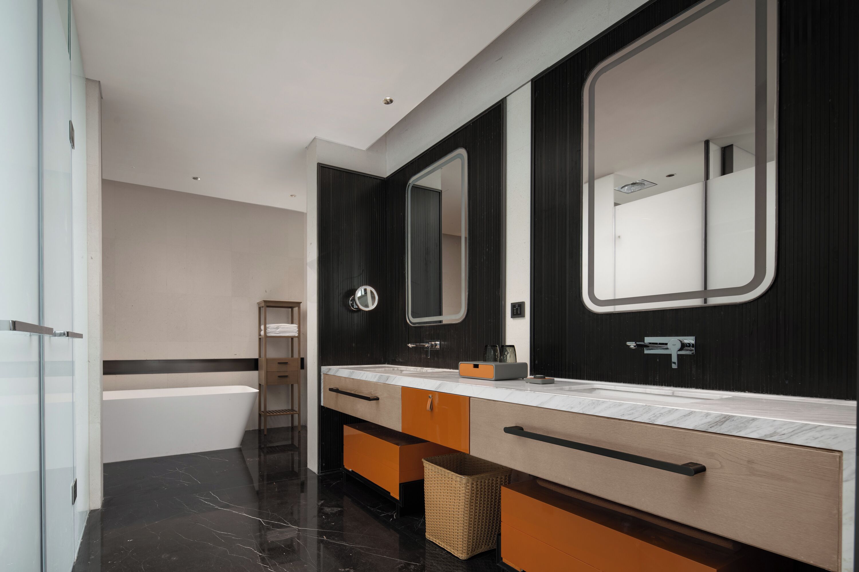 Un baño moderno con lavamanos doble, un espejo grande y una bañera.
