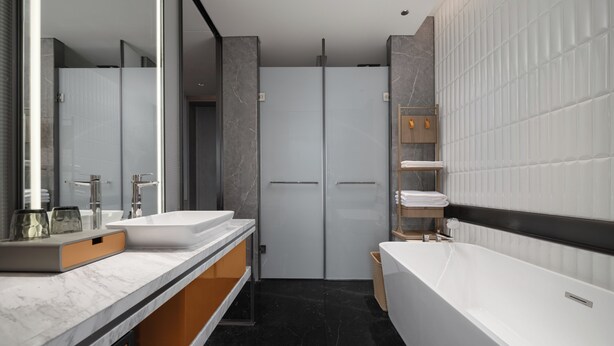 Une salle de bain moderne avec deux lavabos, une grande baignoire et une douche à l’italienne.