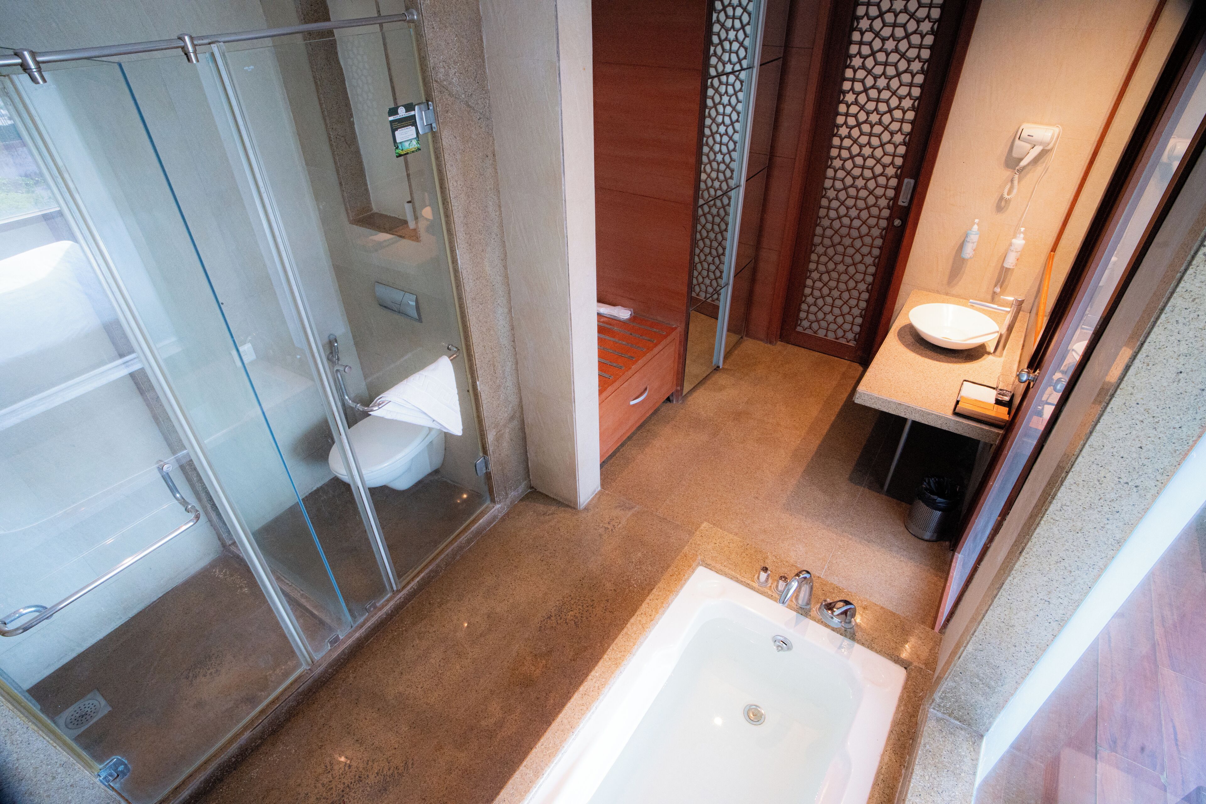 A bathroom with a glass shower enclosure, a bathtub, and a sink with a mirror.