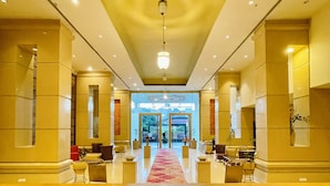 A hotel lobby with a central red carpet, seating areas, and a view of the entrance. - The Sky Imperial Jaipur (Amer)