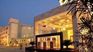 A modern hotel entrance with a well-lit lobby, a fountain feature, and a view of the surrounding buildings. - The Sky Imperial Jaipur (Amer)