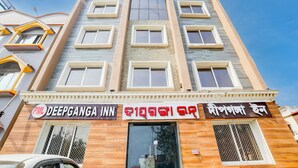 A multi-story building with a sign for 'Deepganga Inn' and another sign with text in a different script. - Deep Ganga inn TripandTrip (Puri)