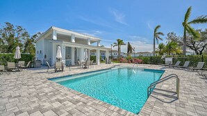 A pool area with a clear blue pool, lounge chairs, and umbrellas. - Sienna Sunset: Serene Townhome w/ Pool and Lanai (Sarasota)